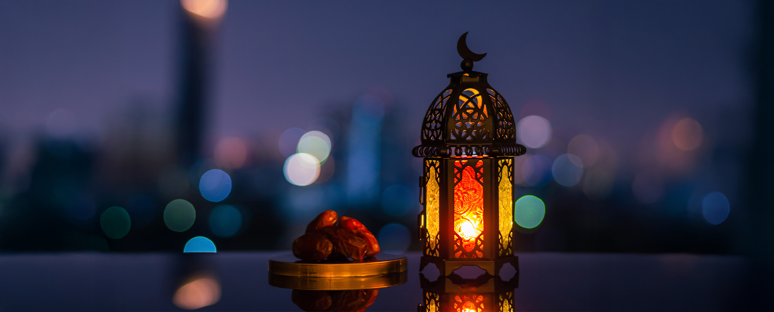 Illuminated Ramadan lantern with dates against a city nightscape, symbolizing the journey from Ramadan to Eid Illuminated Ramadan lantern with dates against a city nightscape, symbolizing the journey from Ramadan to Eid