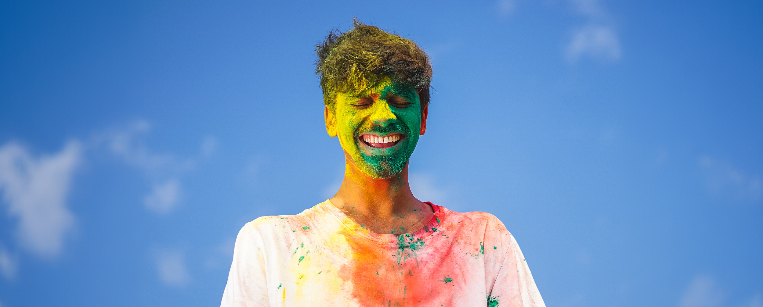 A man with colours on his face smiling and enjoying A man with colours on his face smiling and enjoying