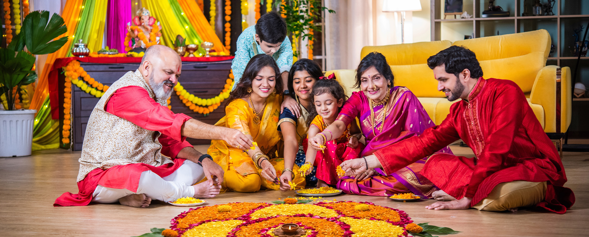 Happy family dressed in traditional attire creating a vibrant Ugadi rangoli with colorful flower petals, celebrating the festive spirit at home. Happy family dressed in traditional attire creating a vibrant Ugadi rangoli with colorful flower petals, celebrating the festive spirit at home.
