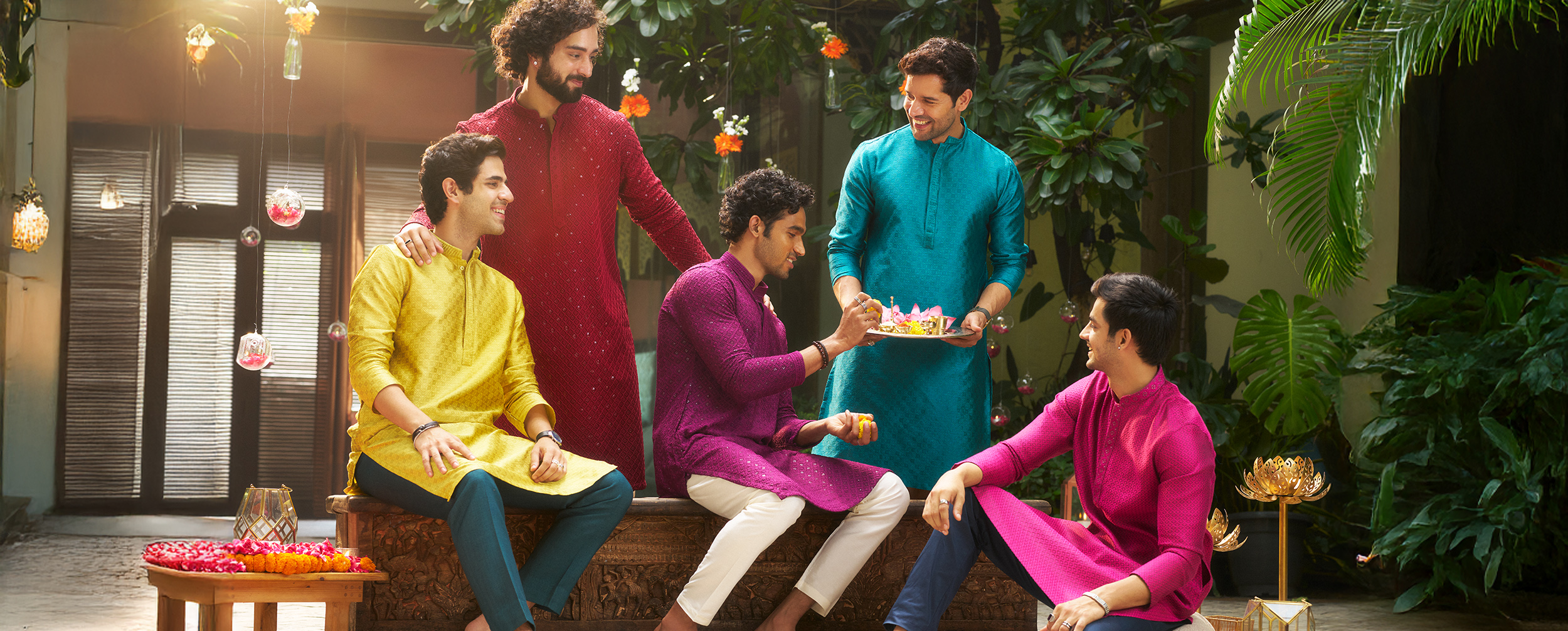 Group of men in colorful traditional kurtas celebrating Durga Puja with festive spirit and rituals