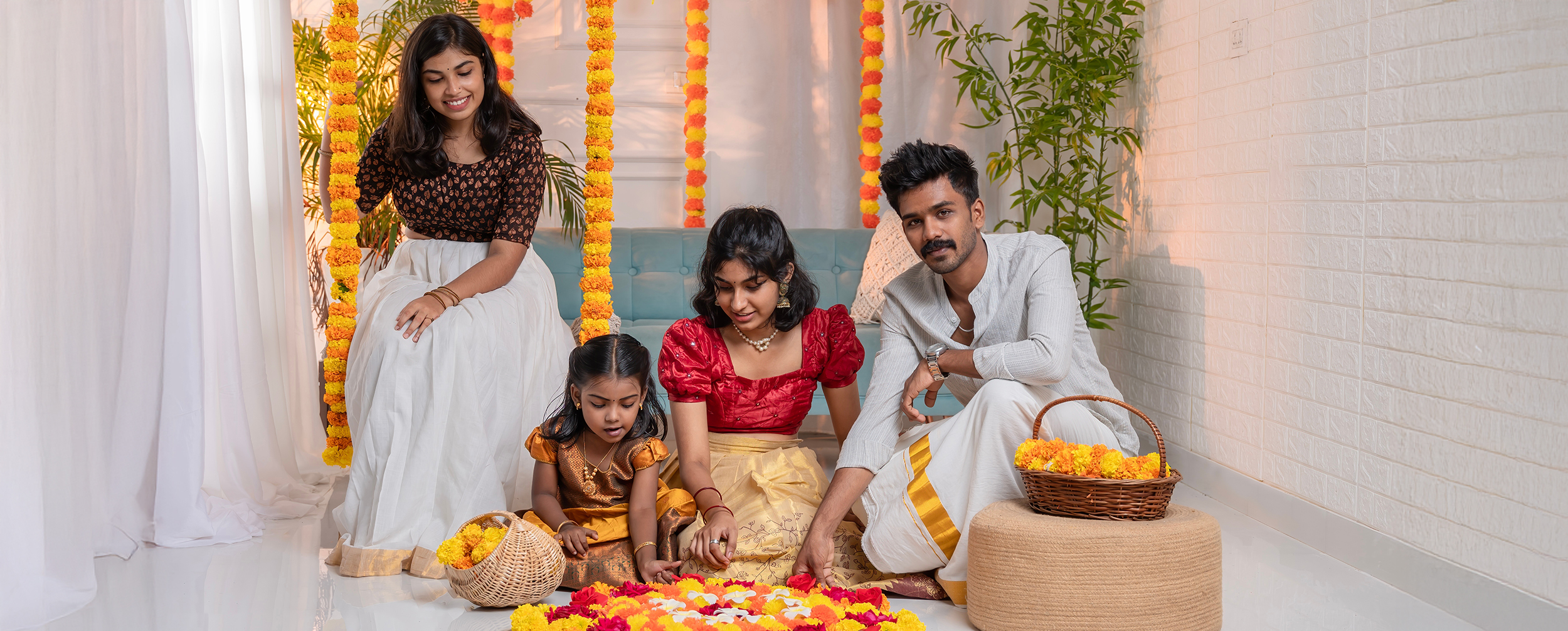 Happy South Indian family dressed in traditional attire creating a vibrant floral rangoli (Pookalam) during Onam celebration with marigold decorations Happy South Indian family dressed in traditional attire creating a vibrant floral rangoli (Pookalam) during Onam celebration with marigold decorations