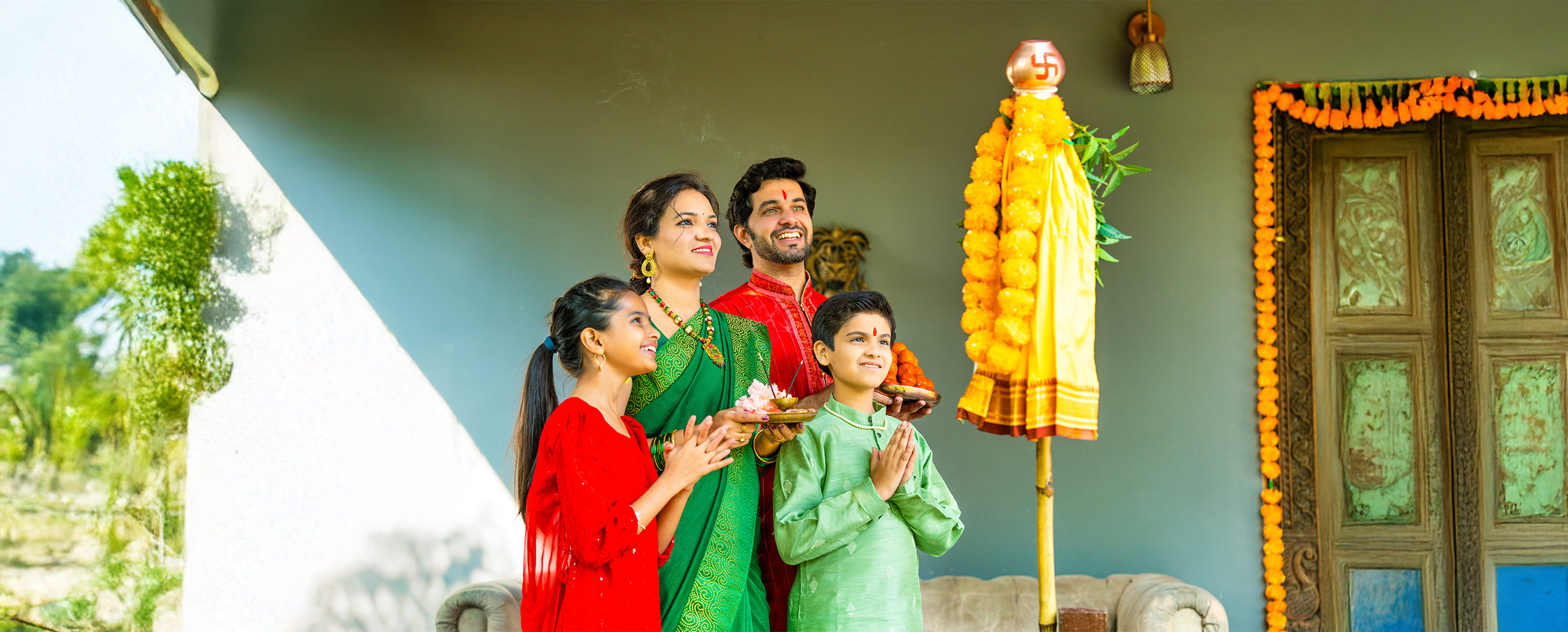 Happy Indian family dressed in traditional attire performing Gudi Padwa puja, worshipping a decorated Gudi at home with devotion and festive decorations. Happy Indian family dressed in traditional attire performing Gudi Padwa puja, worshipping a decorated Gudi at home with devotion and festive decorations.