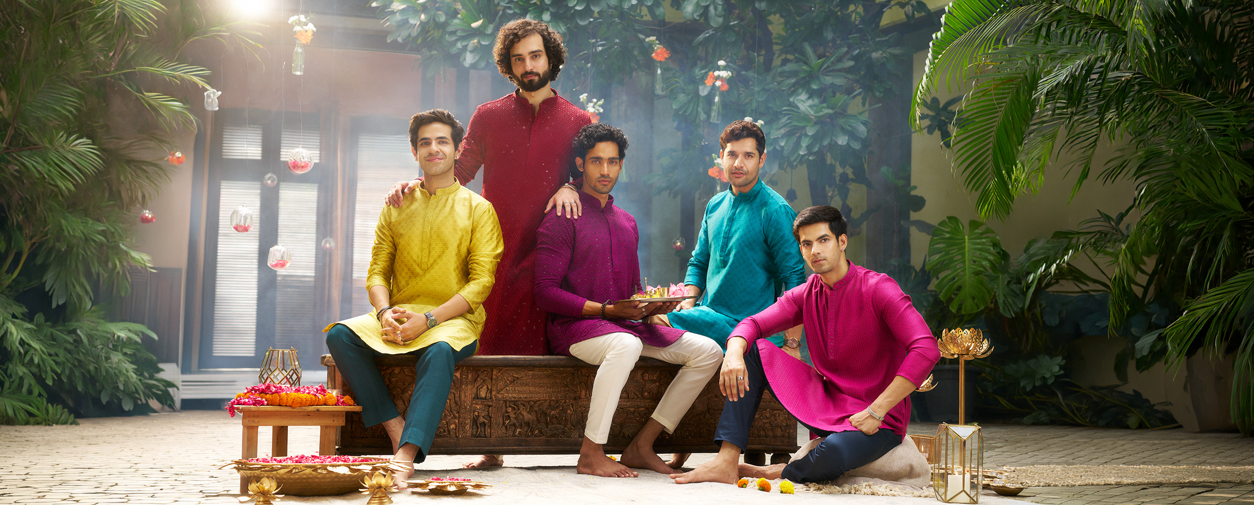 Five men wearing colorful festive kurtas showcase diverse ethnic styles, rich hues, and contemporary traditional fashion for celebrations.