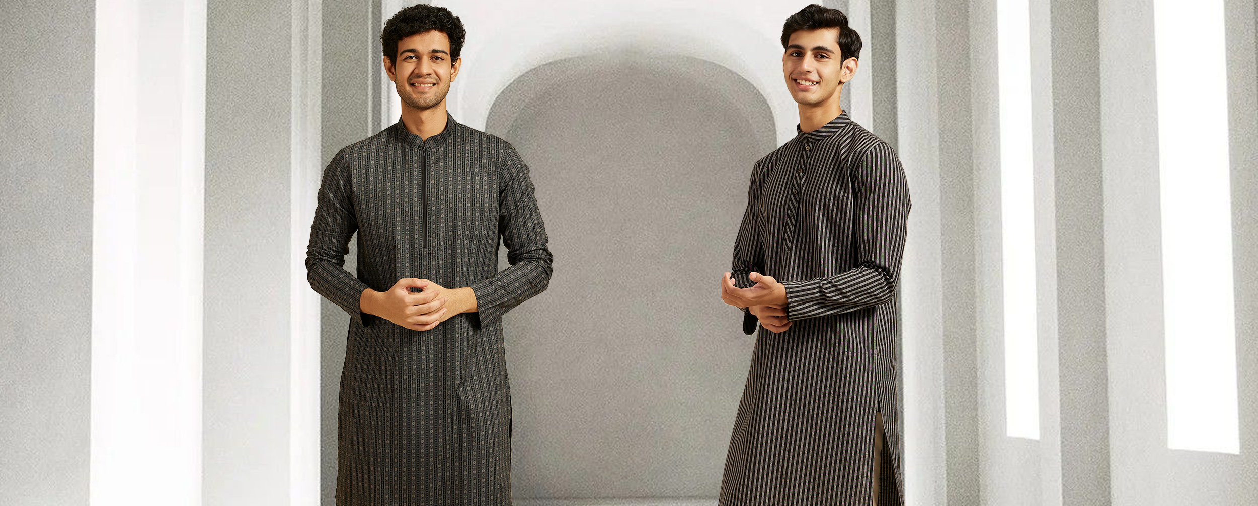 Two men in monochrome ethnic wear — one in a patterned black kurta and the other in a black-and-grey striped kurta, both with mandarin collars, styled for a sleek modern traditional look. Two men in monochrome ethnic wear — one in a patterned black kurta and the other in a black-and-grey striped kurta, both with mandarin collars, styled for a sleek modern traditional look.