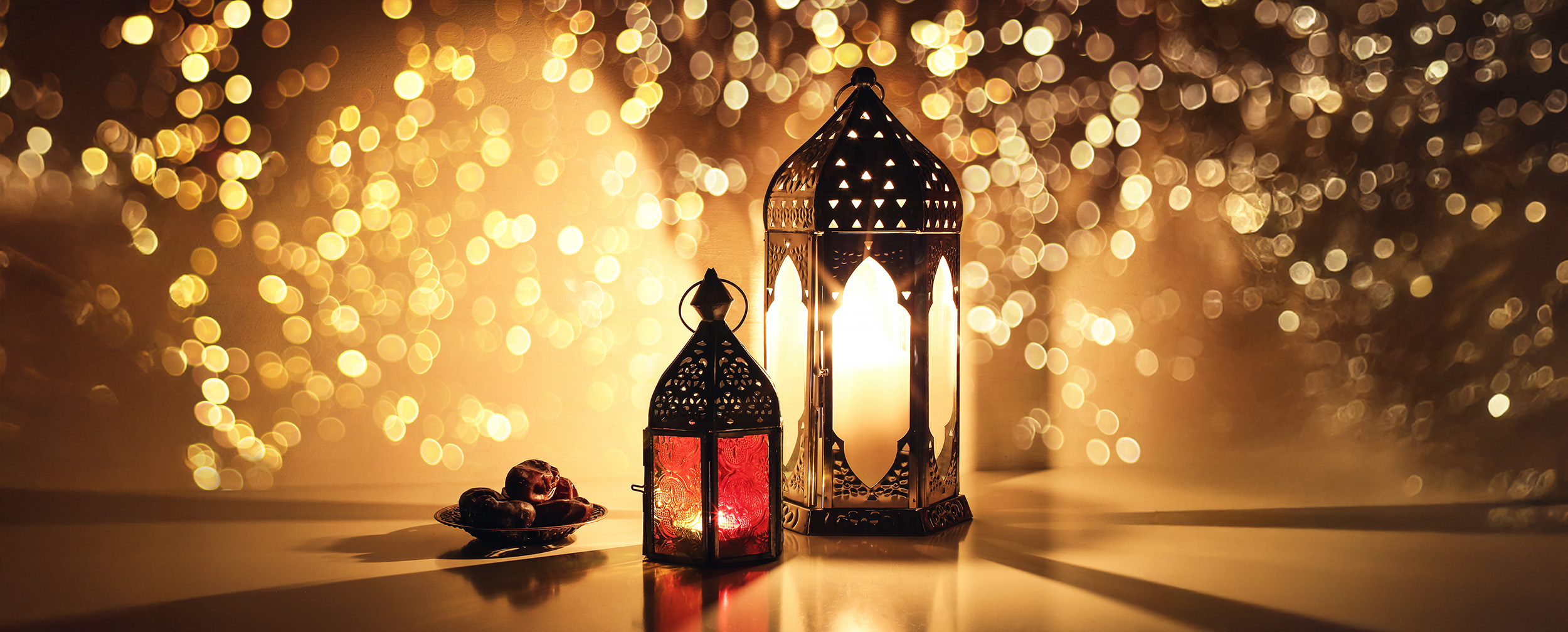 Traditional lanterns and dates with warm festive lights, symbolizing Eid celebrations around the world. Traditional lanterns and dates with warm festive lights, symbolizing Eid celebrations around the world.