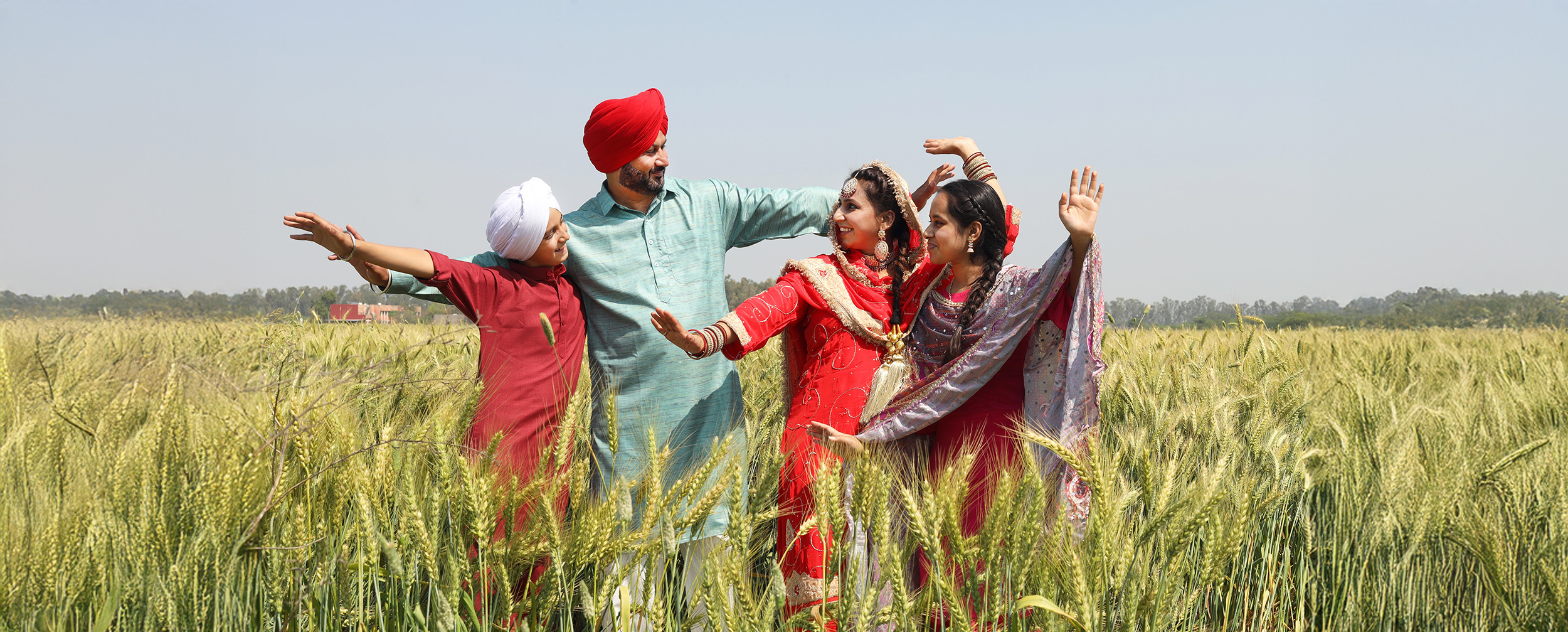 Punjabi family in traditional attire joyfully celebrating Baisakhi in a lush wheat field, showcasing cultural dance and harvest festivity spirit Punjabi family in traditional attire joyfully celebrating Baisakhi in a lush wheat field, showcasing cultural dance and harvest festivity spirit