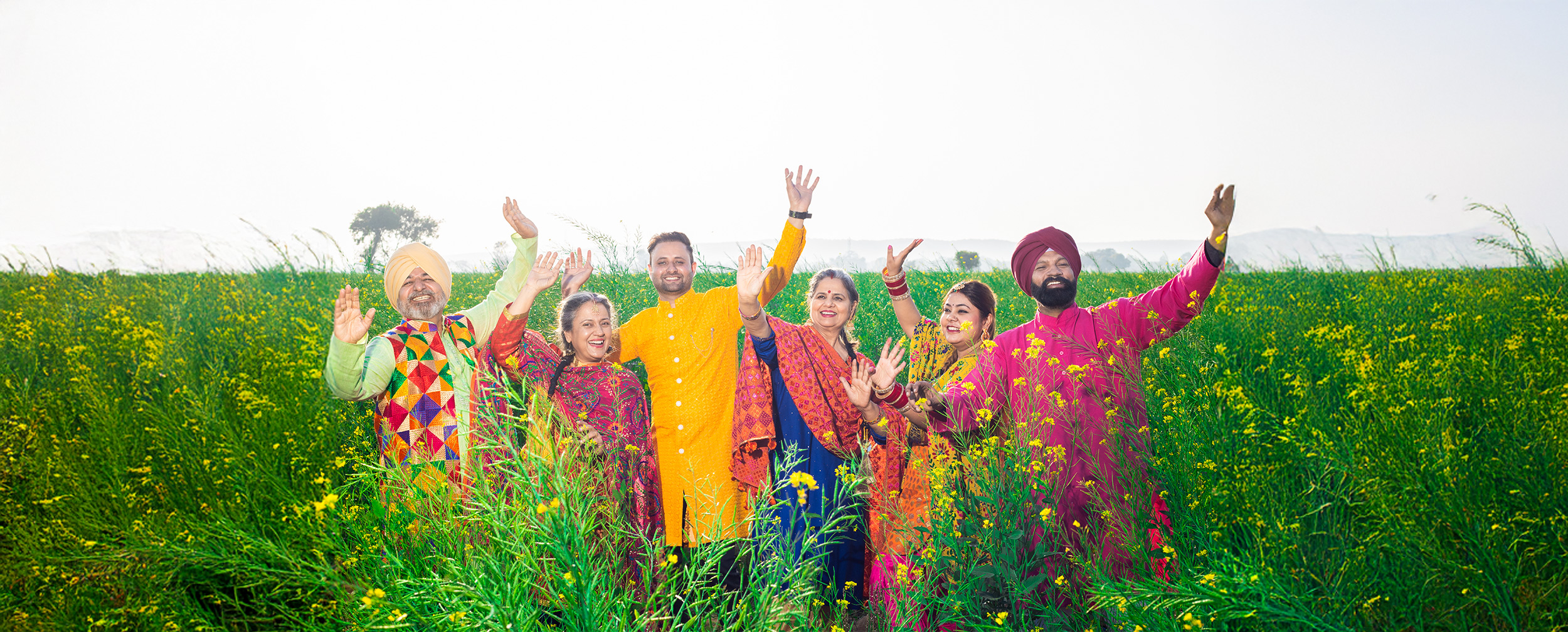 A joyful punjabi family in colorful traditional attire celebrates Baisakhi in a vibrant mustard field. A joyful punjabi family in colorful traditional attire celebrates Baisakhi in a vibrant mustard field.