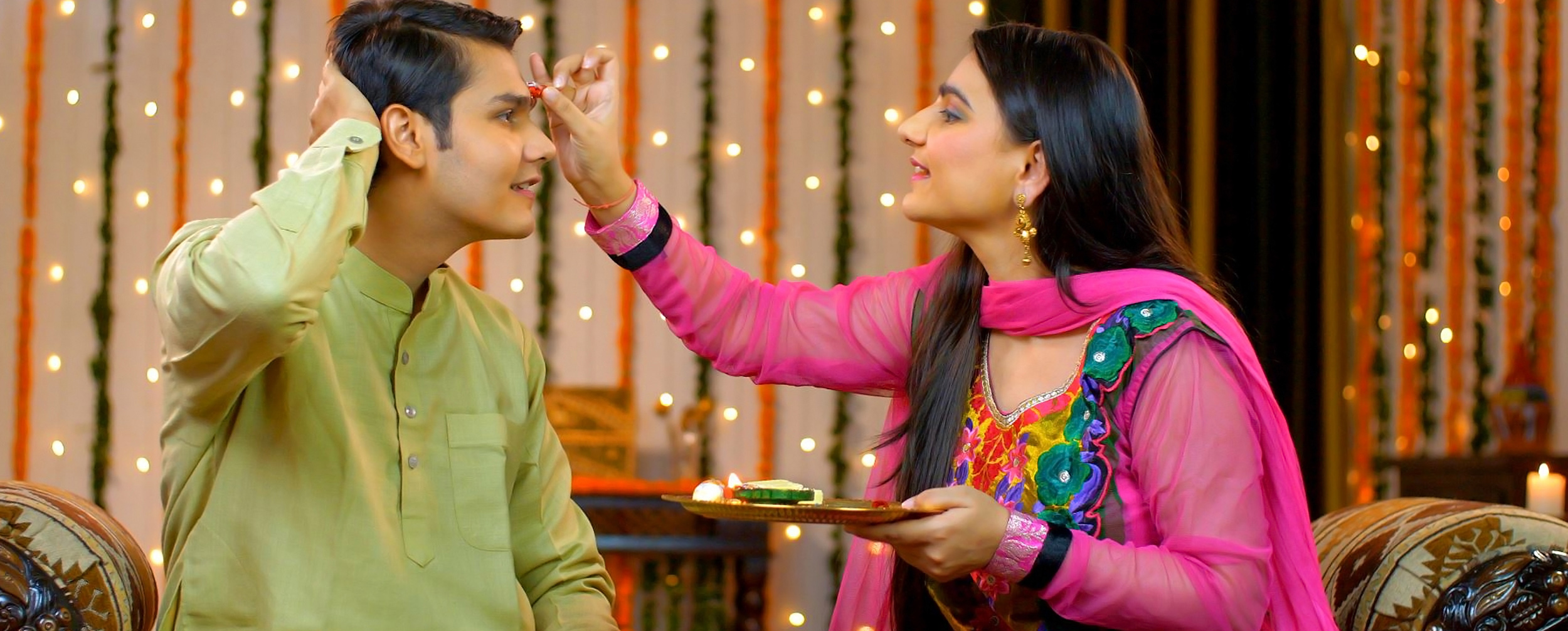 Sister performing the essential tika ceremony ritual on her brother's forehead for the Bhai Dooj festival.