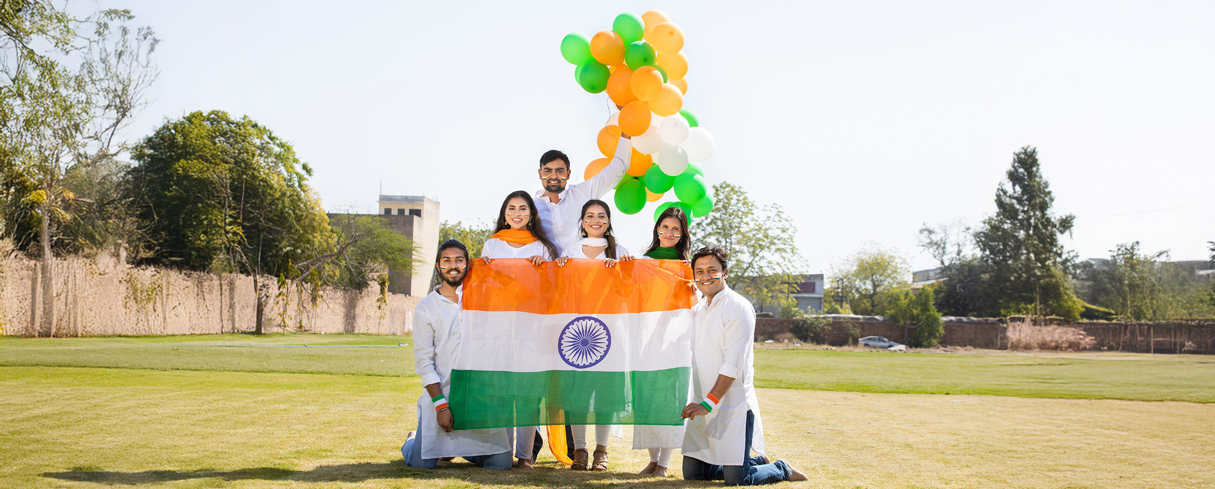 A group of people celebrating republic day with indian national flag and tri color ballons A group of people celebrating republic day with indian national flag and tri color ballons